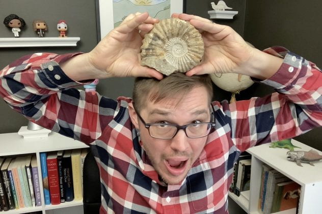 Brandon Hendrickson holding an ammonite